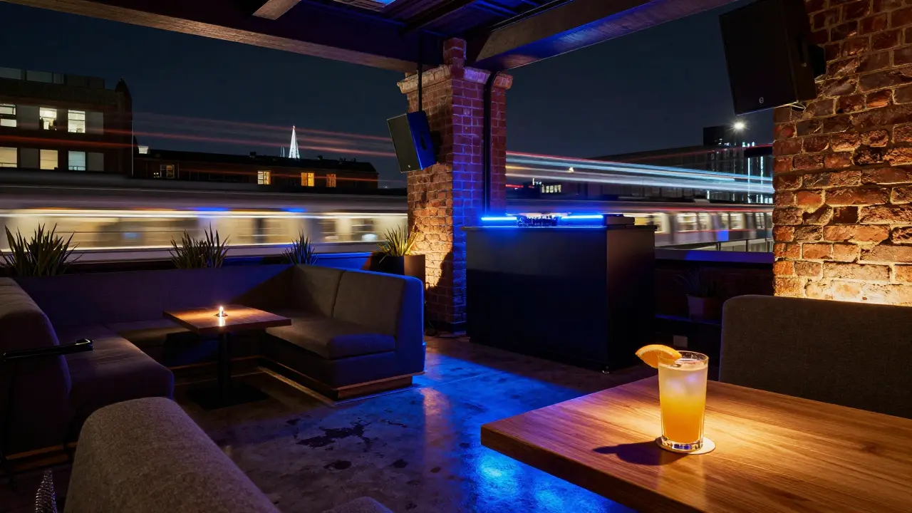 Vibrant rooftop bar at The Standard with industrial decor and neon-lit DJ booth.